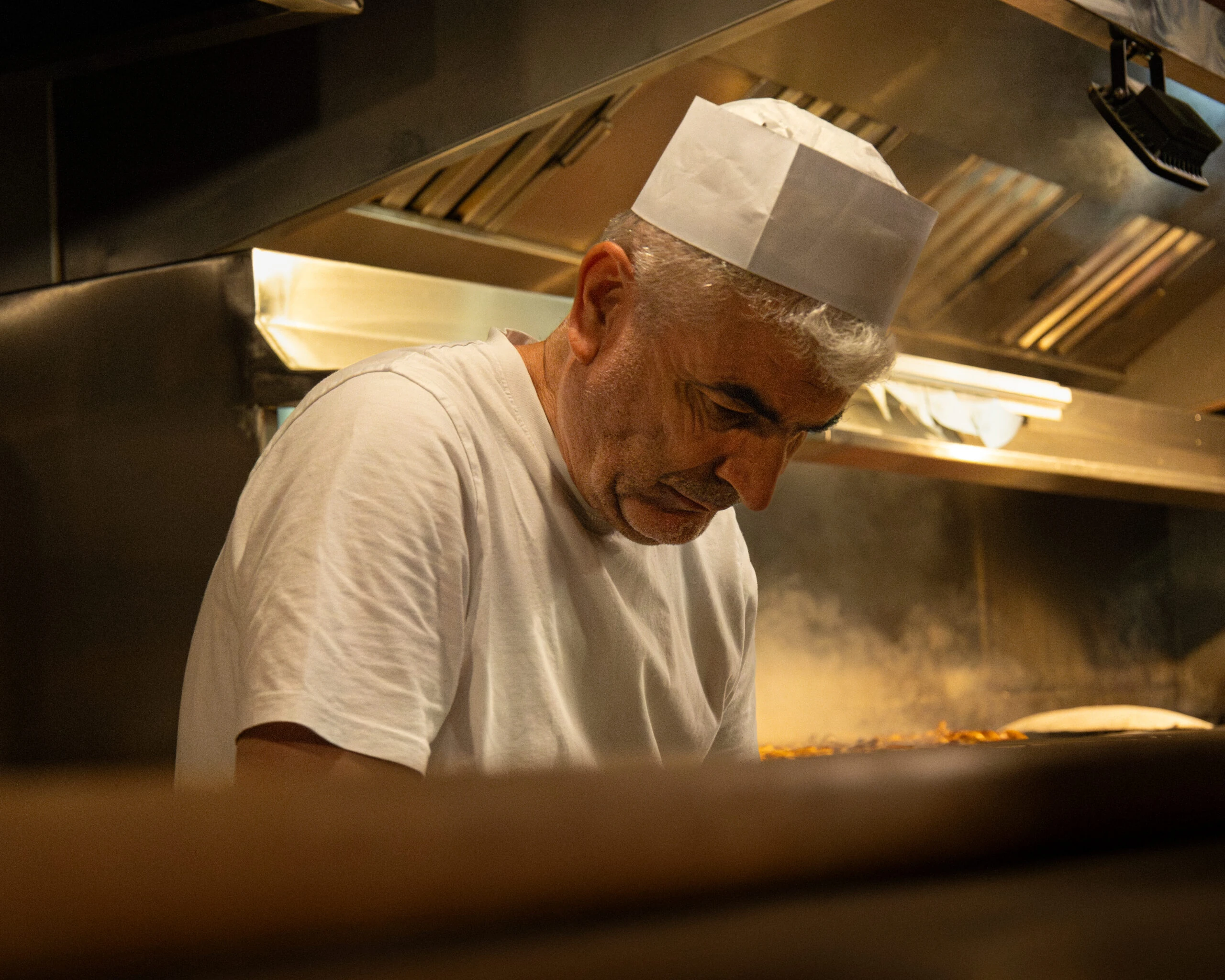 Chef preparing charcoal-cooked dishes in the Midpoint kitchen