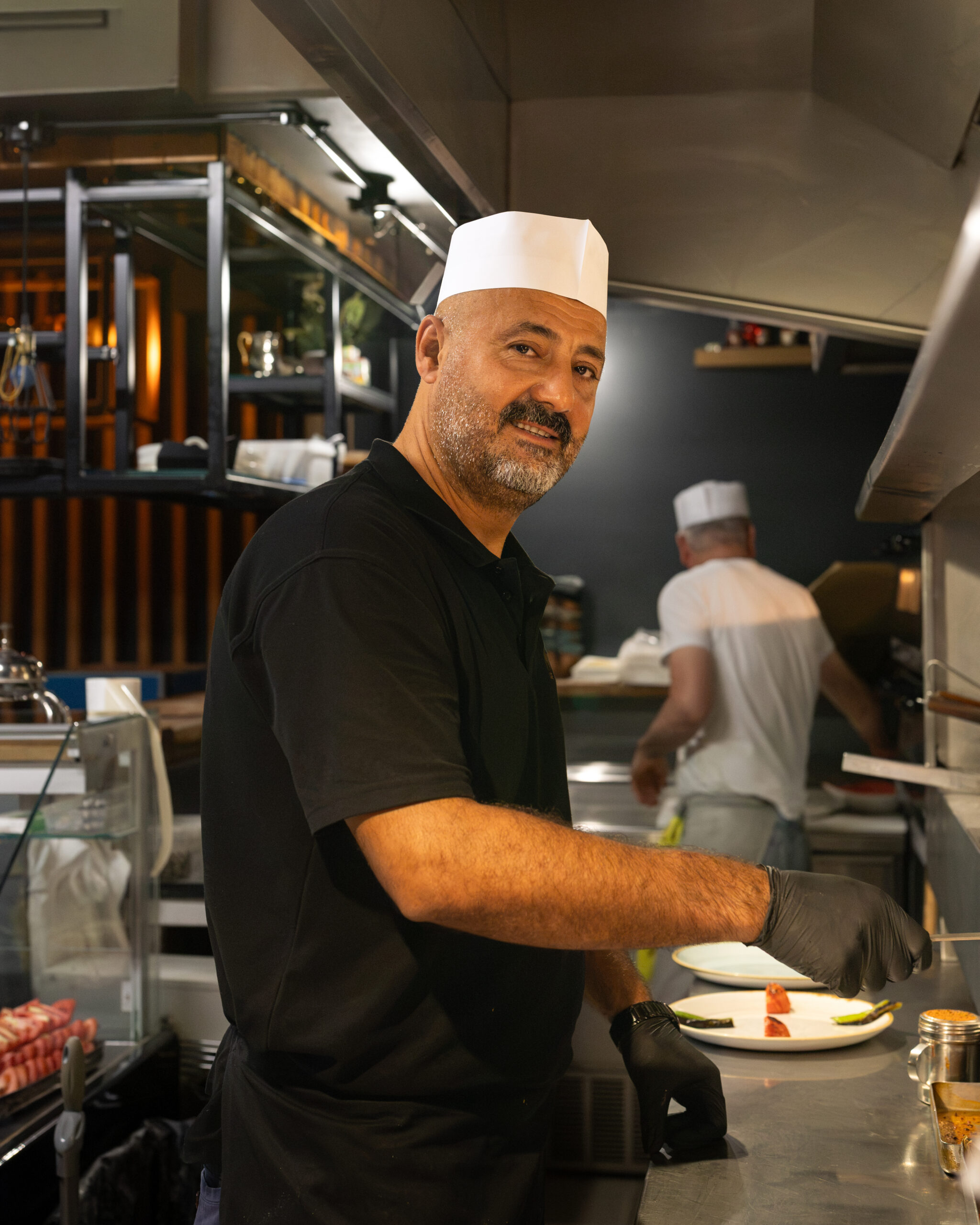Midpoint chef preparing plates in the restaurant kitchen.